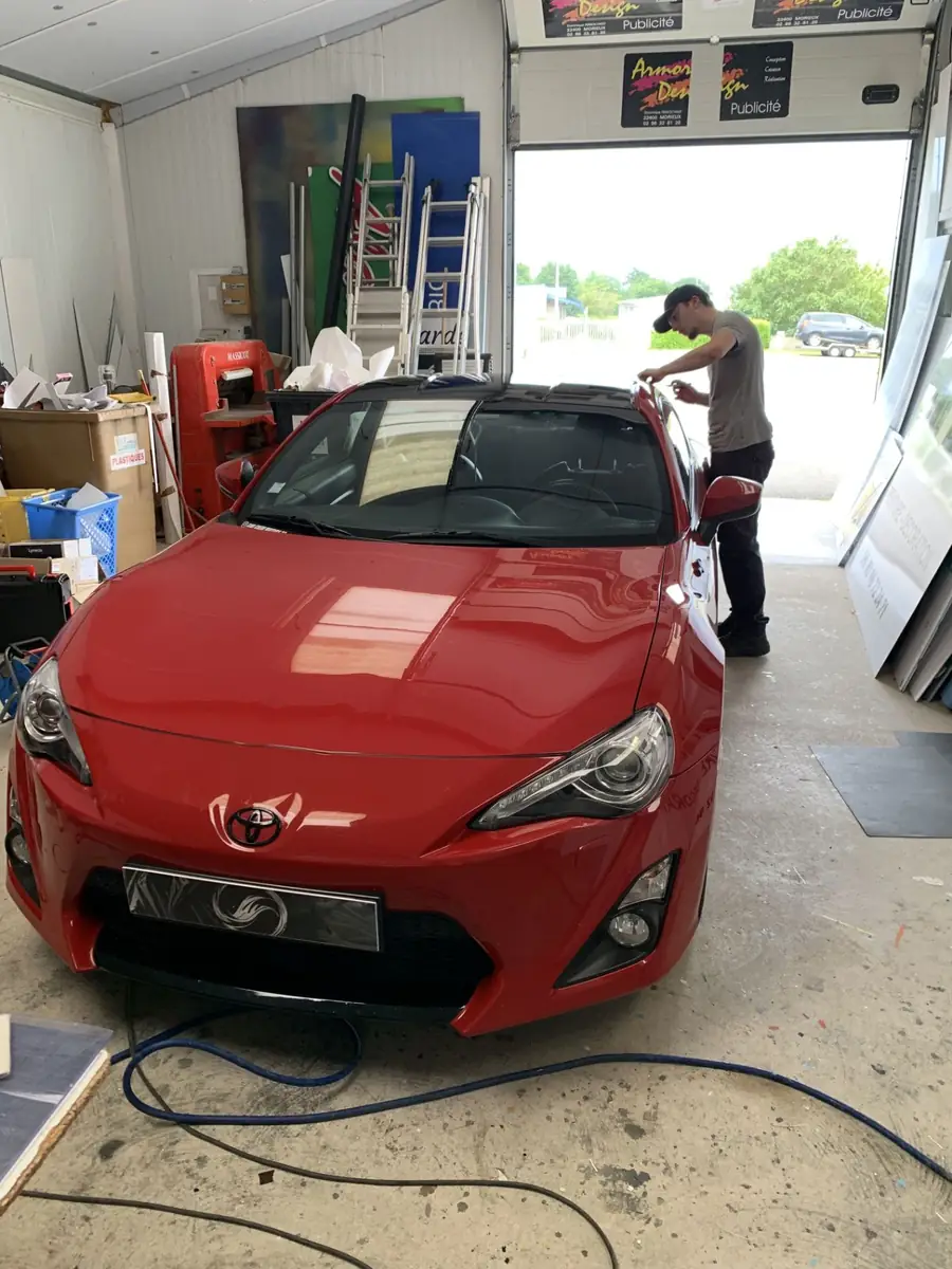 Pose d'un flocage de toit noir sur Toyota GT86 rouge dans l'atelier Armor Design