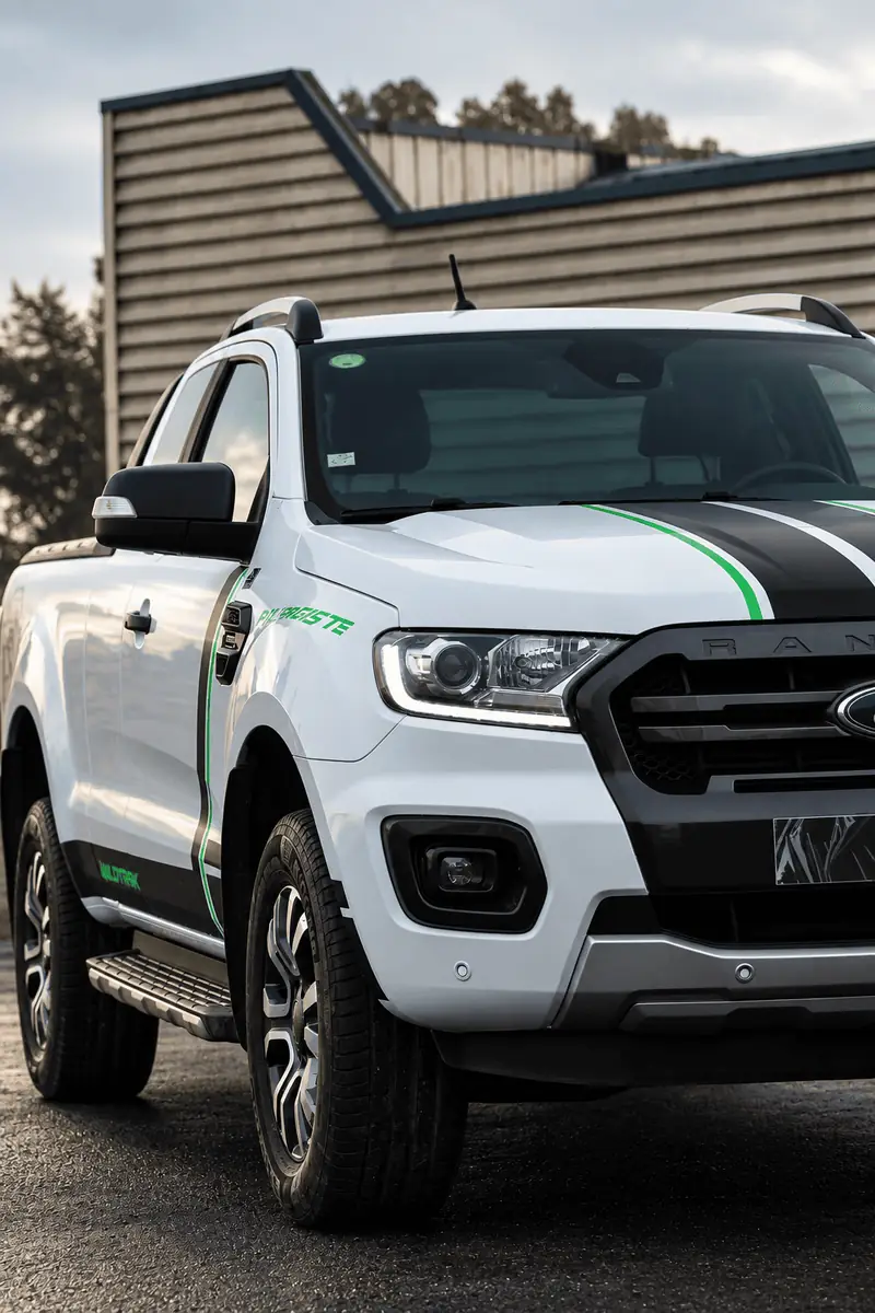 Détail avant d'un pick-up blanc avec bandes de covering noires et vertes